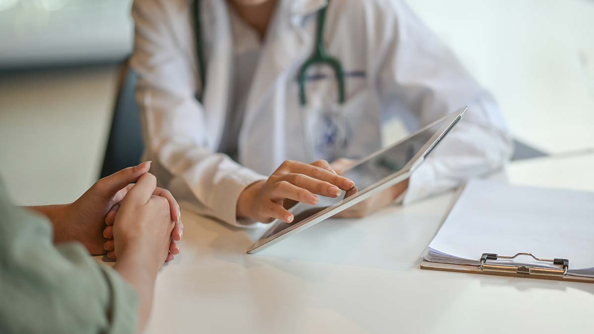 Doctor reviewing medical information with a patient, promoting bone health awareness by an osteoporosis advocate